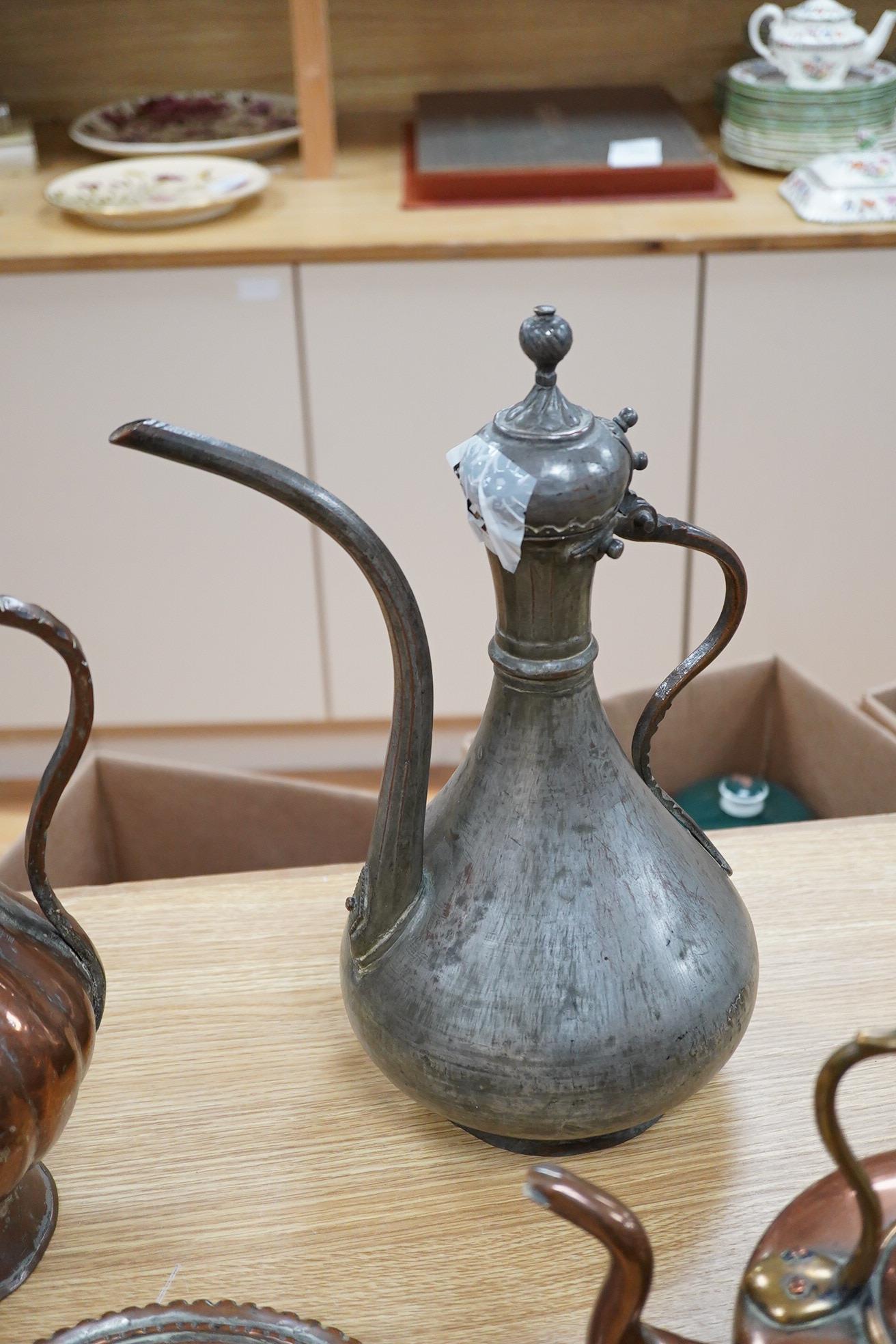 Two Middle eastern tinned copper coffee pots ‘Dallah’ a similar dish and a European copper kettle, tallest 41cm high